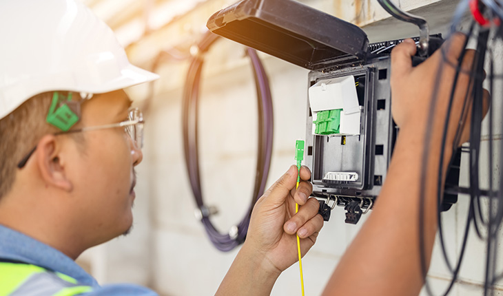 personne qui installe un cable à fibre optique