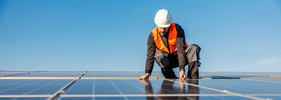 technicien qui pose des panneaux solaires sur un toit