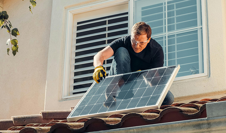 homme qui pose des panneaux solaires
