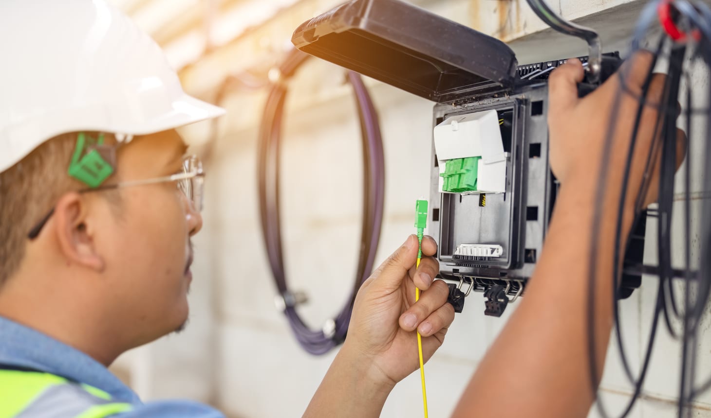 personne qui installe un cable à fibre optique